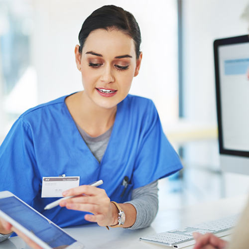 Eine Ärztin in blauer Uniform klärt mit einem Tablet in der Hand eine ältere Patientin zur breiten Patienteneinwilligung der Medizininformatik-Initaitive auf.