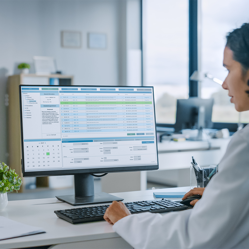 Eine Ärztin arbeitet in einer modernen Klinik an einem Computer mit einer elektronischen Patientenakte.