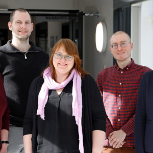 Das Team des Dateninterationszentrums Düsseldorf seht in einem Gang.