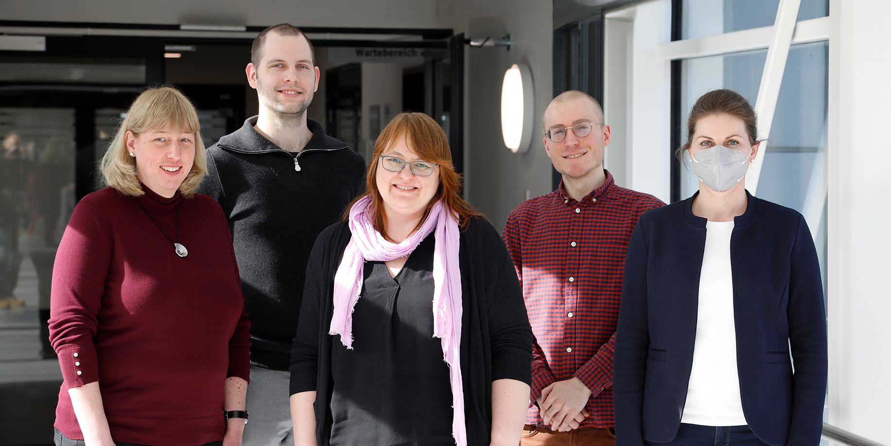 Das Team des Dateninterationszentrums Düsseldorf seht in einem Gang.