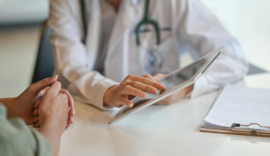 10 000 Patienten Broad Consent Halle_SMITH-News_12092025 Eine Ärztin aus der regionalen Gesundheitsversorgung zeigt einer Patientin auf einem Tablet ihre medizinischen Daten.
